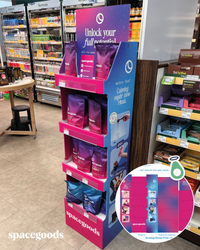 Display stand with purple packages and 'spacegoods' branding in a store setting.